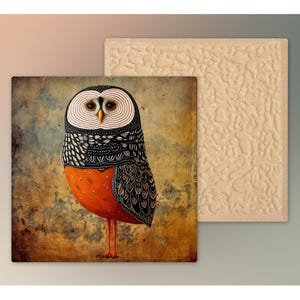 May include: Square ceramic tile featuring a whimsical owl illustration. The owl has a patterned black and white head, orange body with black spots, and brown wings. A second, textured tile is visible.