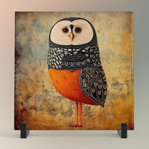 May include: A square art print featuring a stylized owl with a detailed design. The owl has a white and black patterned head, a vibrant orange body, and long orange legs. The background has a textured, aged appearance.