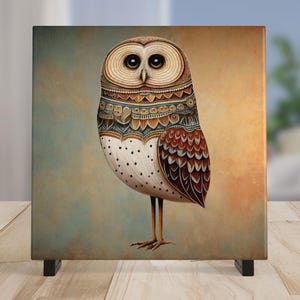 May include: Square canvas art featuring a detailed illustration of an owl. The owl has large, dark eyes and is adorned with intricate patterns in shades of brown, beige, and blue. The owl stands on thin legs against a muted background.