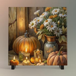 May include: A still-life painting featuring pumpkins, candles, and a vase of white and orange flowers. The pumpkins are various sizes and shapes, with warm orange hues. Lit candles in glass holders add a cozy glow. The scene evokes autumn.