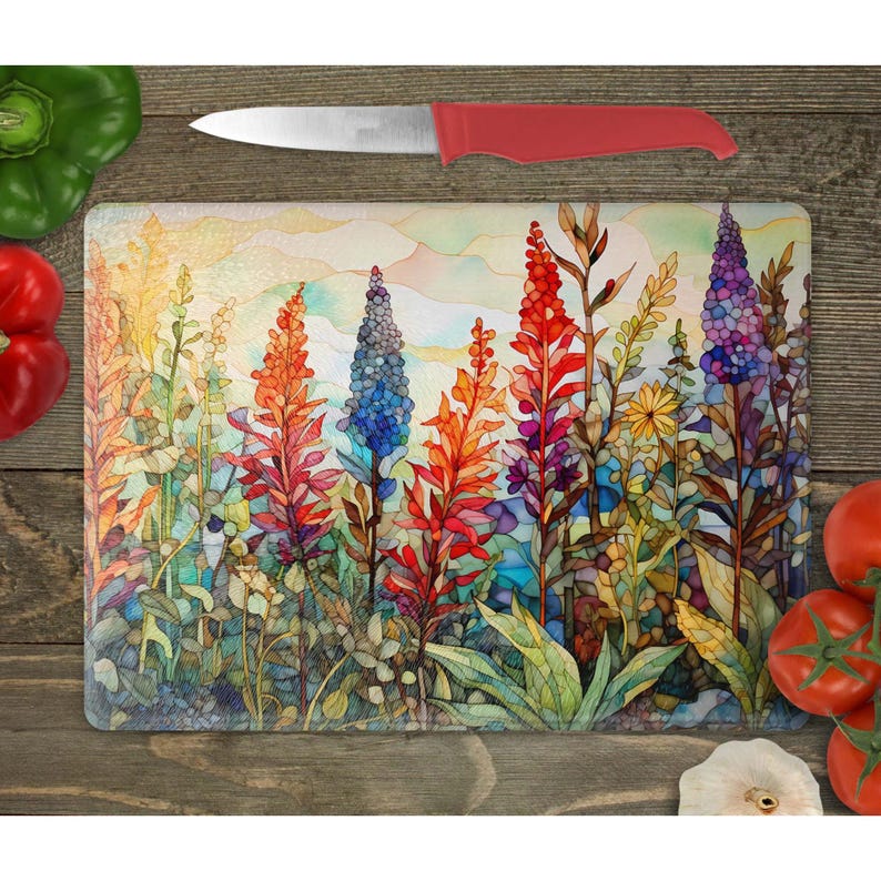 May include: A colorful glass cutting board with a watercolor design of tall flowers in shades of red, blue, yellow, and green. The flowers are arranged in a field with a hazy background.
