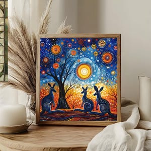 May include: A framed painting with a blue, orange, and yellow color scheme. The painting depicts three kangaroos standing in front of a tree with a large sun behind them. The background is filled with small dots and circles.