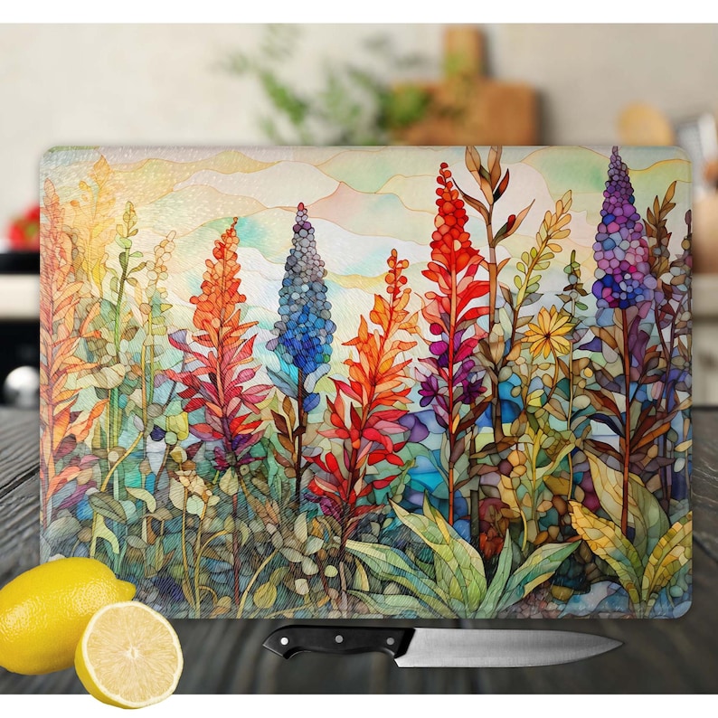 May include: A colorful glass cutting board with a watercolor-style floral design. The design features a variety of flowers in shades of red, blue, yellow, and green. The flowers are arranged in a cluster, with the tallest flowers in the center of the design. The background of the design is a light blue watercolor wash.