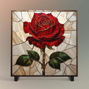 May include: A stained glass panel featuring a vibrant red rose with gold outlines. The rose is set against a background of off-white and tan glass pieces, framed in a dark brown border. Green leaves and a thorny stem complete the floral design.