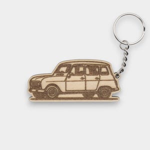 Op de afbeelding: Een houten sleutelhanger met het silhouet van een vintage auto. De sleutelhanger is bruin en heeft een zilveren metalen ring.