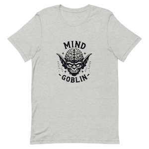 May include: A gray t-shirt with a black and white graphic of a goblin with a brain for a head. The text "Mind Goblin" is printed below the graphic.