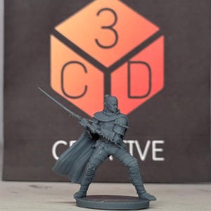 May include: A gray 3D printed miniature of a fantasy character holding a sword. The character is wearing armor and a cloak. The miniature is standing on a round base.