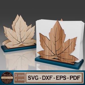 May include: Two wooden leaf-shaped napkin holders. The leaves are light brown with dark brown vein details, set on a teal base. One holder is empty, the other holds white napkins. The image includes text: "SVG - DXF - EPS - PDF".