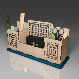 Puede incluir: Organizador de escritorio de madera con un dise&ntilde;o geom&eacute;trico. Tiene cuatro compartimentos para bol&iacute;grafos, l&aacute;pices, tijeras y otros art&iacute;culos de oficina. El organizador est&aacute; hecho de madera clara y tiene una base azul verdosa.