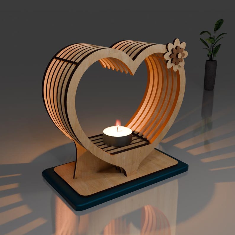 May include: A wooden heart-shaped candle holder with a teal base. The holder has a small, round opening in the centre for a tea light candle.