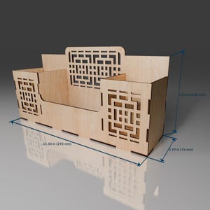 Puede incluir: Un organizador de madera con un dise&ntilde;o geom&eacute;trico. Tiene tres compartimentos y mide 29,2 cm de ancho, 13,3 cm de alto y 7,6 cm de profundidad.