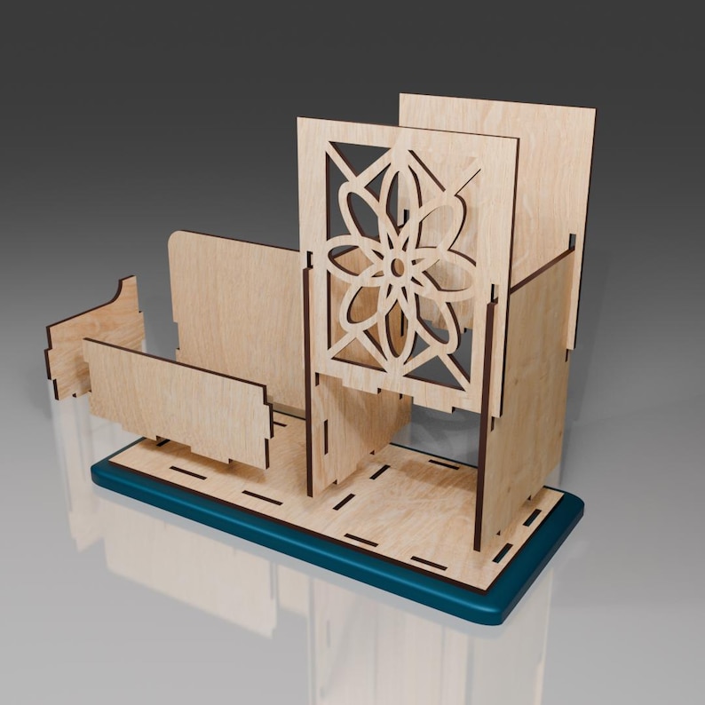May include: A wooden desk organizer with a decorative cutout design. The organizer has a teal base and a compartment with a floral pattern.