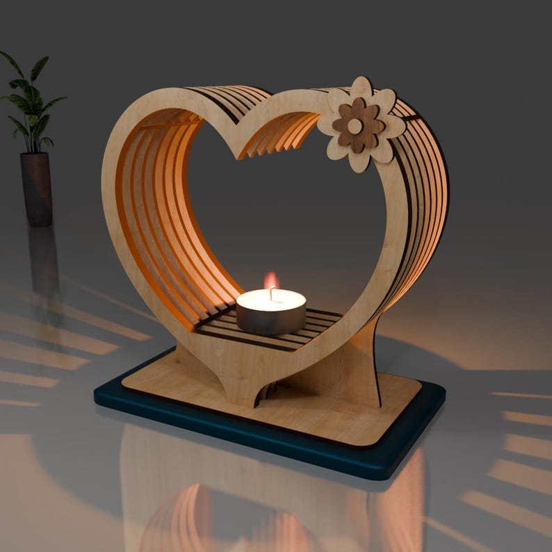 May include: A wooden heart-shaped candle holder with a decorative flower design. The holder has a small shelf for a tea light candle.