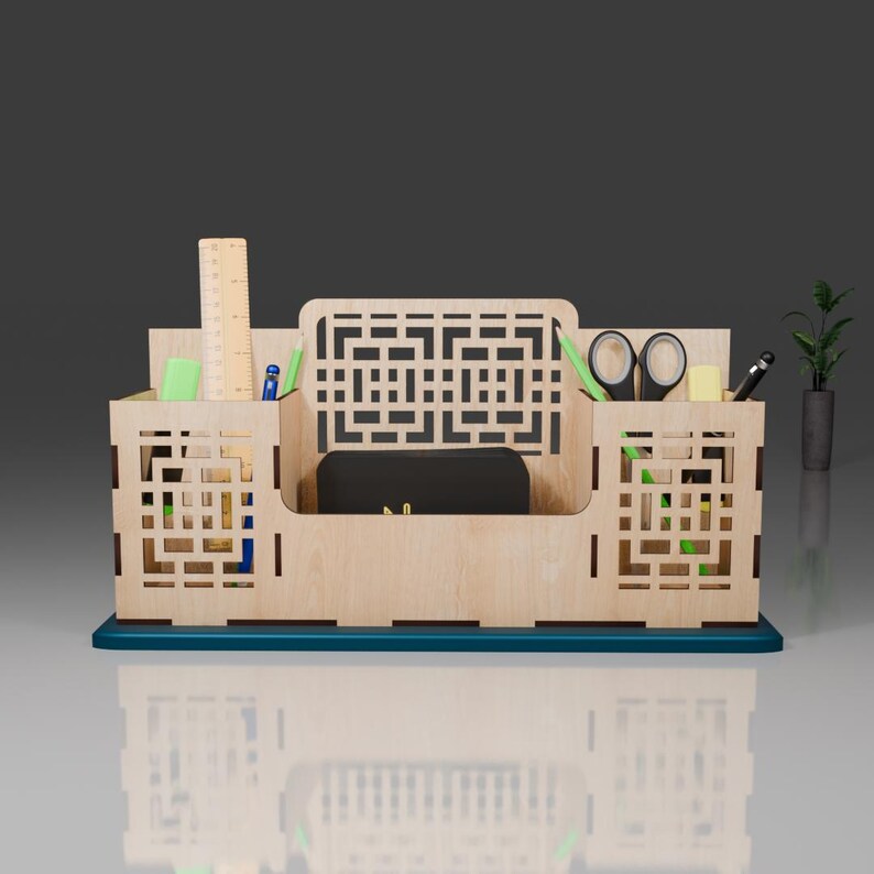 Puede incluir: Un organizador de escritorio de madera con un dise&ntilde;o geom&eacute;trico. Tiene compartimentos para bol&iacute;grafos, l&aacute;pices, tijeras y otros art&iacute;culos de oficina. El organizador est&aacute; pintado de color turquesa en la parte inferior.
