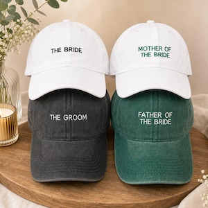 Puede incluir: Cuatro gorras de béisbol dispuestas en dos filas. La fila superior presenta dos gorras blancas con el texto negro THE BRIDE y el texto verde MOTHER OF THE BRIDE. La fila inferior tiene una gorra gris carbón con THE GROOM y una gorra verde oscuro con FATHER OF THE BRIDE.