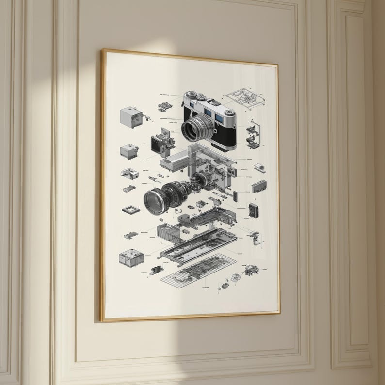 The image is a framed print depicting the internal components of a camera, including the lens, shutter, and various other parts.