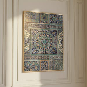 May include: Framed artwork featuring a detailed mosaic design. The mosaic showcases intricate patterns in shades of blue, teal, and gold, with a central starburst motif. The artwork is encased in a gold frame, adding a touch of elegance to the piece.