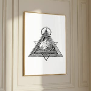 May include: Black and white framed print featuring a detailed illustration of a geometric symbol. The artwork includes a triangle, a circle, and a central circular design with a map-like image. The print is displayed in a gold frame.