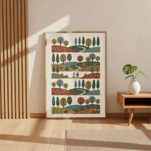 May include: A framed art print with a folk art landscape design. The artwork shows rolling hills, trees, and winding paths in a repeating pattern. The colour palette includes shades of green, brown, and blue.