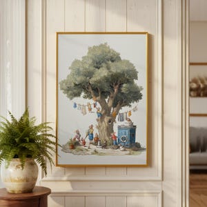Puede incluir: Una impresión en acuarela enmarcada representa una escena caprichosa de animales antropomórficos lavando la ropa en un gran árbol. El árbol tiene tendederos con prendas colgadas, y una lavadora azul está en la base. La obra de arte está en un marco dorado.