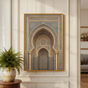 May include: A framed print featuring an ornate architectural design with arched doorways and intricate geometric patterns in shades of blue, beige, and gold. The artwork is displayed on a white wall, with a potted fern in the foreground.