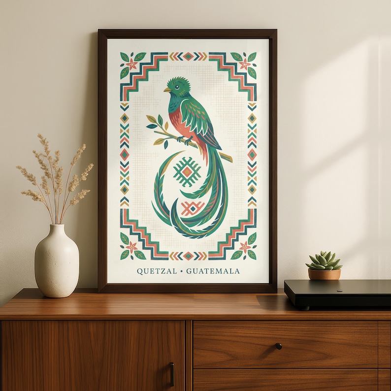 a framed poster of a colorful bird, specifically a quetzal, which is a type of parrot native to Guatemala. The poster is displayed on a wooden dresser, accompanied by a small potted plant and a black speaker.