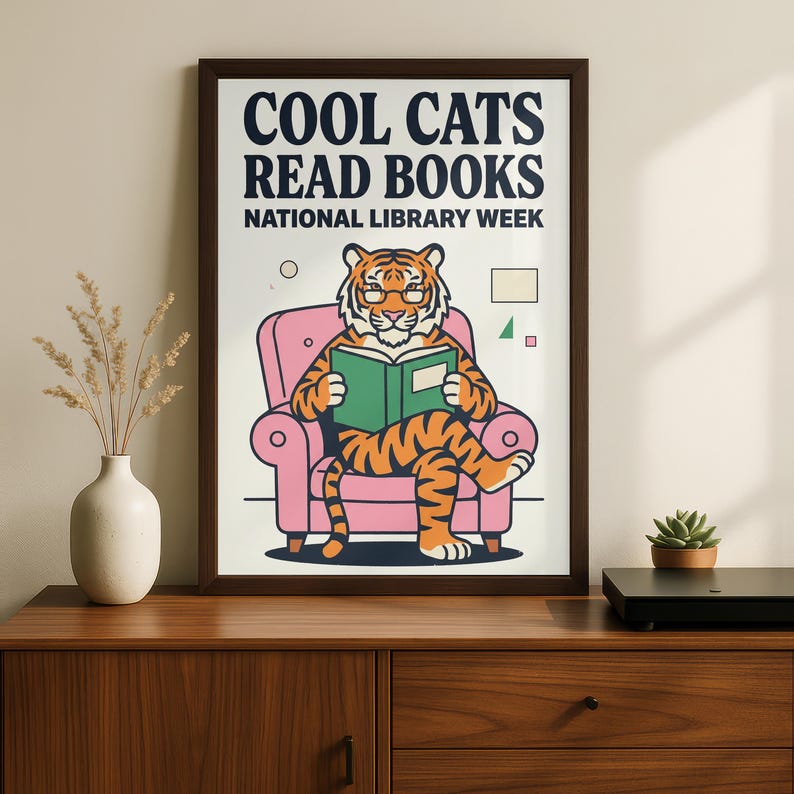 A framed poster with a cartoon tiger sitting in a pink chair and reading a book, celebrating National Library Week.