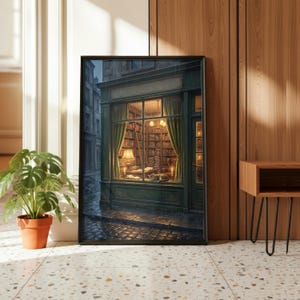 May include: Framed art print depicting a cozy bookstore scene. The artwork features a shop with a lit interior, visible through the window. Bookshelves, a lamp, and a cat are inside. The exterior shows a rainy street and cobblestone pavement.