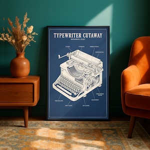 May include: A framed wall art print titled Typewriter Cutaway Mechanical Study, featuring a detailed technical line drawing of a vintage typewriter on a blue background with labels pointing to components like the platen, typebars, and ribbon spools.