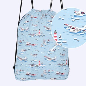 Könnte beinhalten: Eine blaue Kordeltasche mit einem weißen und roten Muster aus Wasserflugzeugen, Leuchttürmen und Eisflächen. Die Tasche hat schwarze Kordeln und ein weißes Futter.