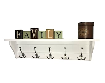 May include: White wooden shelf with five double hooks and a decorative wooden sign that reads "FAMILY".