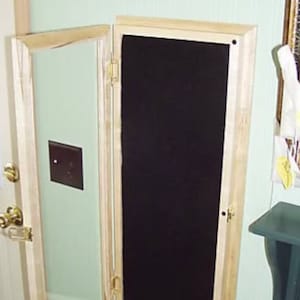 May include: A wooden framed mirror with a black fabric backing. The mirror is hinged and can be opened to reveal the fabric backing.