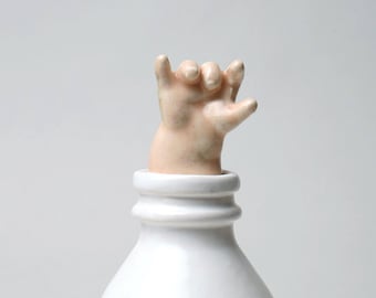 Baby Hand Emerging from Milk Bottle - Stopper with a Cause