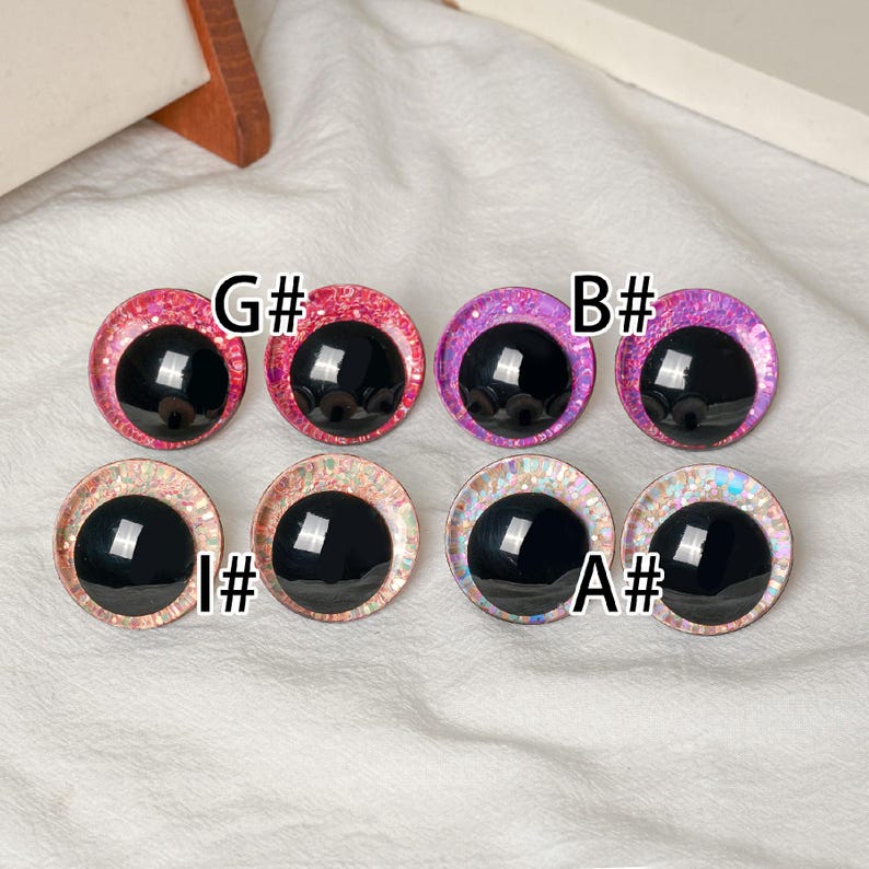 Pu&ograve; includere: Otto occhi rotondi e colorati per l'artigianato con pupille nere. Gli occhi hanno bordi glitterati in rosa, viola e colori iridescenti. Ogni coppia &egrave; etichettata con un simbolo di nota musicale e una combinazione di lettera e numero.