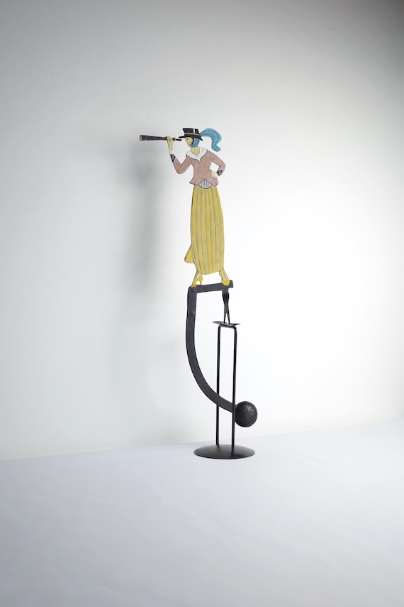 A Victorian woman with telescope that actually balances and moves — vintage-styled metal kinetic figurine with real shelf presence and 83 hearts to back it up.