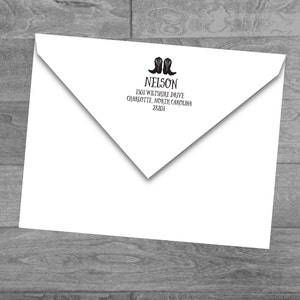 May include: White envelope with a black illustration of cowboy boots and the name "NELSON" printed at the top. The address "1301 WILTSHIRE DRIVE, CHARLOTTE, NORTH CAROLINA 28201" is printed below the name.