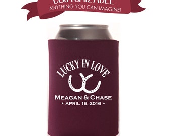 May include: Burgundy can cooler with white text that reads "Lucky in Love" with two white horseshoes. Below the text is "Meagan & Chase * April 16, 2016 *"