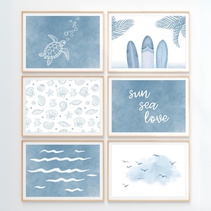 Pode incluir: Seis impress&otilde;es art&iacute;sticas emolduradas com tema costeiro. As impress&otilde;es apresentam desenhos em aquarela de uma tartaruga marinha, pranchas de surf, conchas, as palavras "sol mar amor", ondas do oceano e p&aacute;ssaros. A paleta de cores &eacute; principalmente azul e branco.