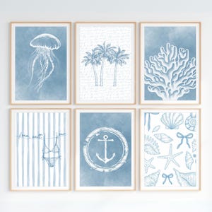 Pode incluir: Seis impress&otilde;es art&iacute;sticas emolduradas com tema costeiro. Cada impress&atilde;o apresenta um design diferente em tons de azul e branco, incluindo uma &aacute;gua-viva, palmeiras, coral, um fato de banho, uma &acirc;ncora e conchas.