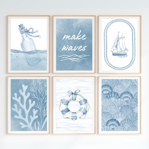 Pode incluir: Seis impress&otilde;es art&iacute;sticas emolduradas com tema n&aacute;utico em tons de azul. As impress&otilde;es apresentam uma mensagem em texto branco, um veleiro, um salva-vidas, uma mensagem em uma garrafa, corais e um padr&atilde;o de conchas. As molduras s&atilde;o de madeira clara.