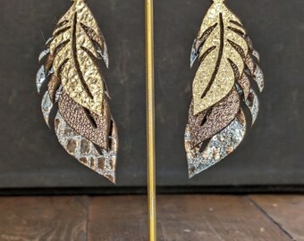 Elevate style with laser-cut feather leather earrings. Artisan crafted for a unique, trendy look, adding elegance to any outfit