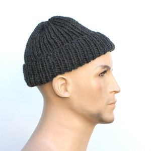 May include: A dark gray knitted beanie hat with a folded brim.