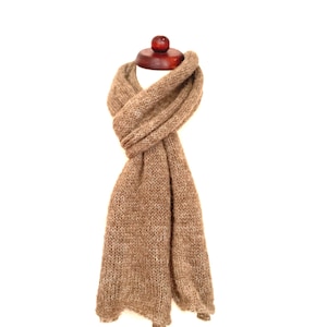 May include: A brown, knitted scarf draped over a wooden mannequin head. The scarf is a solid color, with a textured appearance. The scarf is made of a soft, warm material, perfect for cold weather.