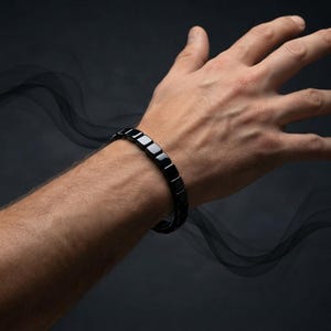 May include: A bracelet composed of smooth, glossy black square-shaped beads linked together in a continuous row. The beads have a reflective surface and are arranged in a uniform pattern, creating a sleek, dark accessory worn around the wrist.