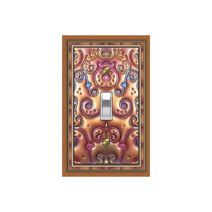 May include: Decorative light switch cover with an ornate, embossed design in shades of copper, pink, and blue. The cover features a toggle switch and is framed in a brown border. The design includes swirling patterns and decorative accents.