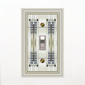 May include: A decorative light switch cover with an Art Deco design. The cover features a rectangular shape with a central switch and intricate patterns in blue, gold, and silver. Two gold-colored rivets are visible. The design is framed by a double border.