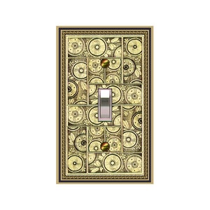 May include: A light switch cover with a decorative design featuring a repeating pattern of circles and leaves in shades of gold and brown. The switch cover has a gold frame with a black border.