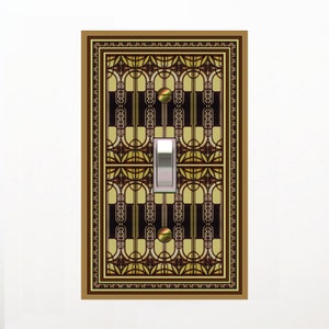 May include: A light switch cover with a decorative design featuring geometric shapes in shades of brown, gold, and cream. The design resembles a stained glass window.