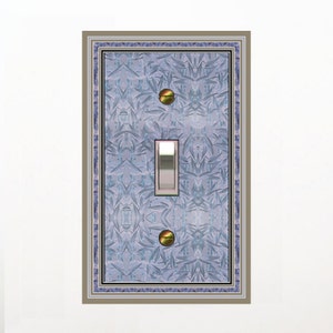 May include: A light switch cover with a blue and white patterned design. The cover has a silver light switch and two gold screws.