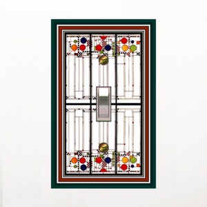 May include: A decorative light switch cover with a stained glass design. The cover features a geometric pattern with red, blue, orange, and green circles, and a silver switch. The frame is dark green and brown.